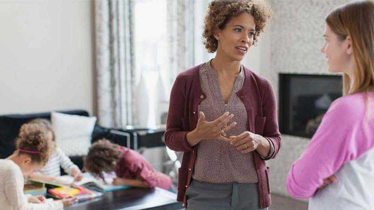 Mom giving babysitting instructions to babysitter.